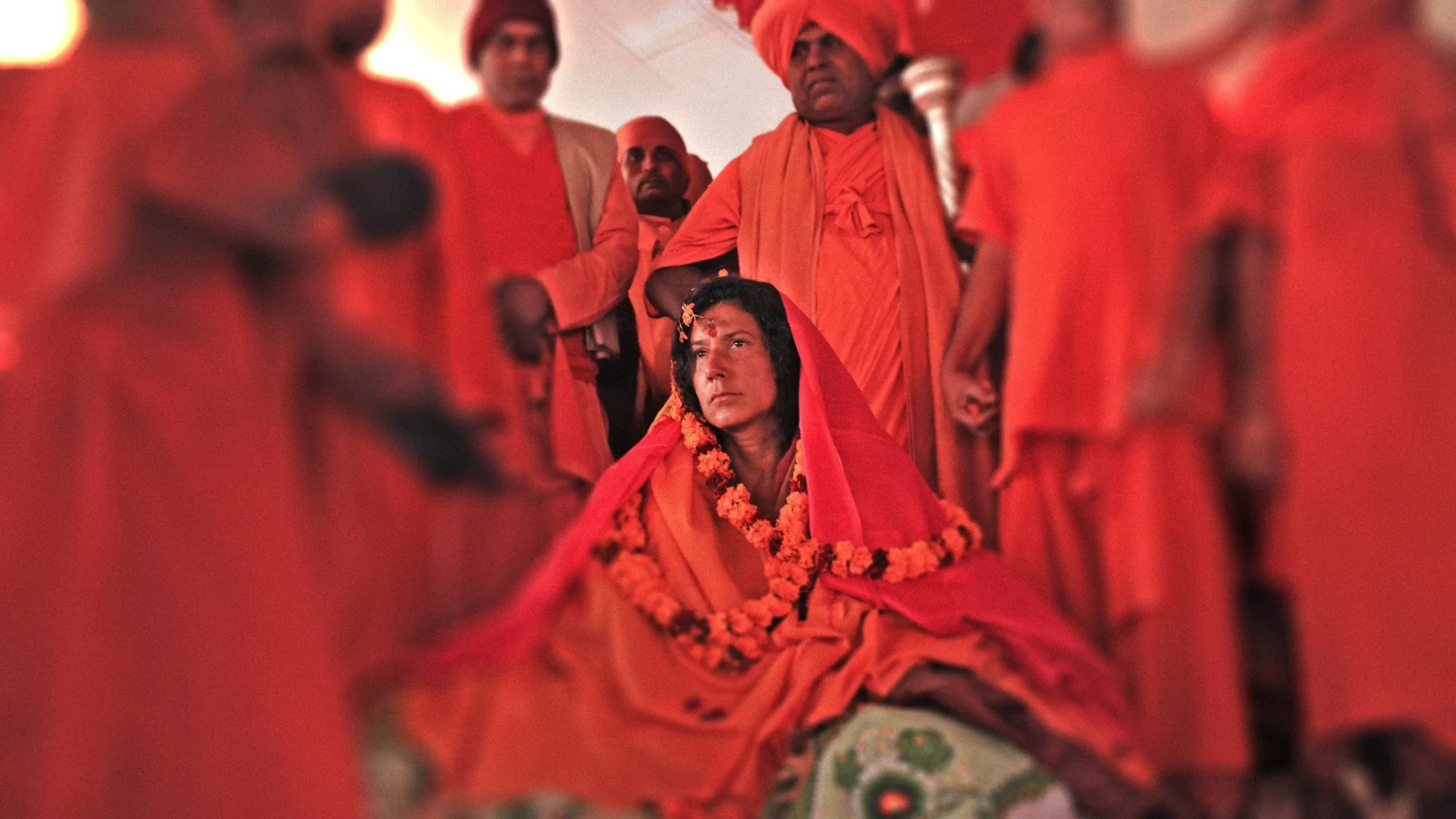 Mataji Shaktiananda con velo y guirnalda naranja entre maestros de la tradición védica