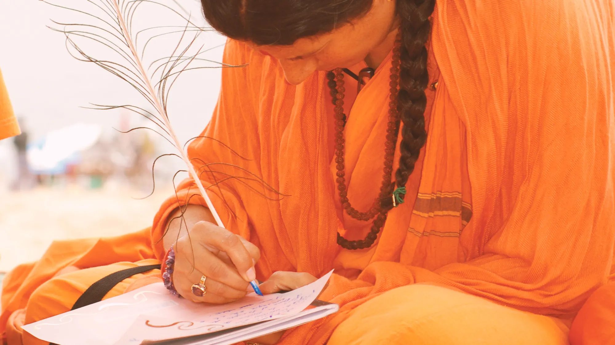 Mataji Shaktiananda vestida de naranja escribiendo